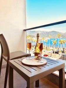 a table with two glasses of wine and a view of the ocean at FİFTY5 SUİTE HOTEL in Marmaris