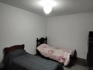 dos camas sentadas una al lado de la otra en un dormitorio en D&D alojamiento en Guaymallén