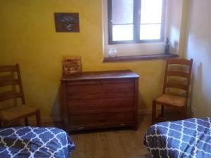 a bedroom with two beds and a dresser and a window at nature en petite montagne in Arinthod