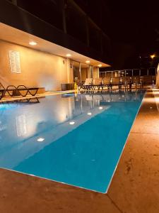 una piscina notturna con sedie intorno di FİFTY5 SUİTE HOTEL a Marmaris
