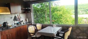 a kitchen with a table and chairs and a large window at Motel in Qusar