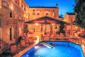 a swimming pool in front of a building at Kastro Hotel in Spetses