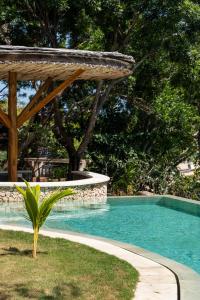 einen Pool mit einer hölzernen Pergola und einem Pool in der Unterkunft Morin Resort in Nusa Lembongan