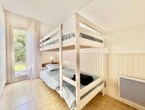 1 Schlafzimmer mit 2 Etagenbetten und einem Fenster in der Unterkunft Jolie maison familiale in Valbonne