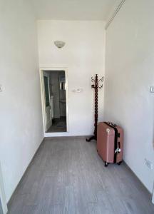 une chambre vide avec une valise et un couloir dans l'établissement Comodo appartamento nel centro!, à Maglie