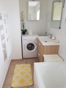 y baño con lavadora y lavamanos. en Appartement T3 meublé, St Evarzec Bretagne - Le Degemer-Mat, en Saint-Évarzec