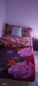 a bed in a room with pink roses on it at Wummies place in Abu Dhabi