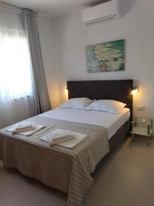 een slaapkamer met een groot bed en handdoeken bij Orchid SeaView Apartment With Garage Parking in Zaton