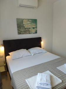 a bedroom with a large white bed with two towels on it at Orchid SeaView Apartment With Garage Parking in Zaton