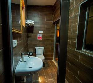 ein Bad mit einem Waschbecken und einem WC in der Unterkunft Nap Apartment Hotel in Dansoman