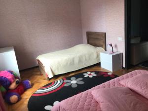 a bedroom with two beds and a teddy bear on the floor at Sweet Home in Kutaisi