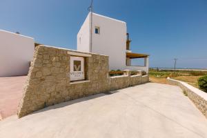 a building with a stone wall in front of a building at Velonis Villa with private pool and sea view in Agia Anna Naxos