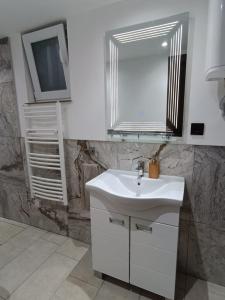 a bathroom with a white sink and a mirror at Carefree Apartments in Ulcinj