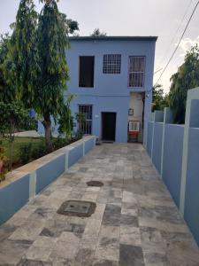 斋浦尔Saket Guest House Jaipur的一座有蓝色栅栏和人行道的白色房子