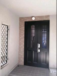 a black front door of a house with a window at IIIハウス　ひらパーからすぐの３階建て一軒家　全寝室エアコン新調　wifi完備　旅行&ビジネス大歓迎 in Hirakata