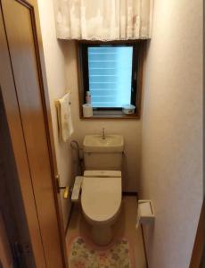 a small bathroom with a toilet and a window at IIIハウス　ひらパーからすぐの３階建て一軒家　全寝室エアコン新調　wifi完備　旅行&ビジネス大歓迎 in Hirakata