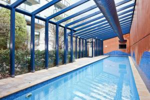 an indoor swimming pool with a glass ceiling at Spacious apartment minutes from the CBD in Melbourne