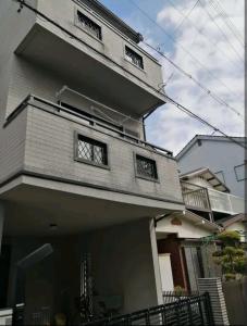 a house with two windows on the side of it at IIIハウス　ひらパーからすぐの３階建て一軒家　全寝室エアコン新調　wifi完備　旅行&ビジネス大歓迎 in Hirakata