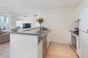 cocina con paredes blancas y encimera en Spacious apartment minutes from the CBD en Melbourne