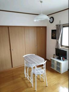 a living room with a table and two chairs at IIIハウス　ひらパーからすぐの３階建て一軒家　全寝室エアコン新調　wifi完備　旅行&ビジネス大歓迎 in Hirakata