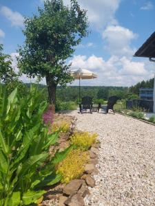 a patio with two chairs and an umbrella at B&B Manderscheid-Blick in Pantenburg