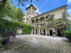 a large building with a ivy covered wall and a courtyard at Palazzo Ronchelli in Castello Cabiaglio