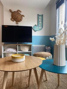 - un salon avec une table et une télévision dans l'établissement Bel Apt neuf - HyperCentre 400m Plage-Pkg-Wifi-T3, à Arcachon