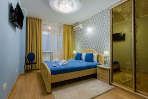 a bedroom with a blue bed and a mirror at Poznyakoff Aparthotel in Kyiv