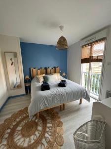 una camera da letto con un grande letto con pareti blu di Bel Apt neuf - HyperCentre 400m Plage-Pkg-Wifi-T3 ad Arcachon