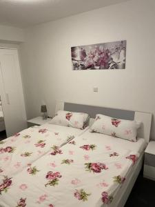Un dormitorio con una cama con flores rosas. en Büschem Wohlfühlparadies, en Lindlar