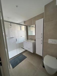 W łazience znajduje się toaleta, prysznic i umywalka. w obiekcie Bel Apt neuf - HyperCentre 400m Plage-Pkg-Wifi-T3 w Arcachon