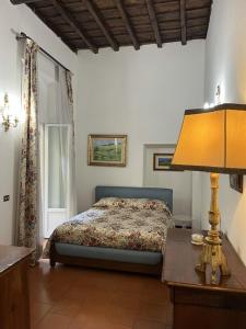 a bedroom with a bed and a table with a lamp at Annemary Maison in Rome