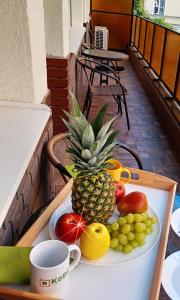 a plate of fruit on a table with a pineapple at Corner Apartment in Budapest