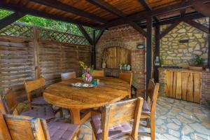 comedor al aire libre con mesa de madera y sillas en Apartmani Ana, en Dramalj