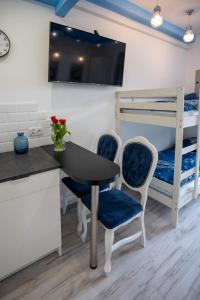 Zimmer mit einem Schreibtisch, Stühlen und einem Etagenbett in der Unterkunft Solne Apartamenty Luna in Wieliczka