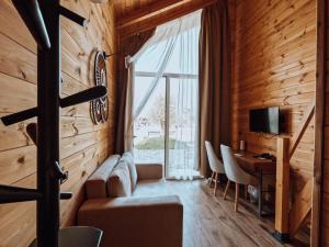 - un salon avec un canapé, un bureau et une fenêtre dans l'établissement Hysaj Agroturizëm, à Shkodër