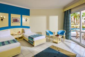 a hotel room with two beds and a balcony at Dreams Beach Resort - Sharm El Sheikh in Sharm El Sheikh