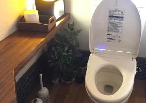 a bathroom with a toilet with plants in it at Kannomori in Yufuin