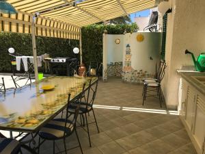 un patio con un lungo tavolo, sedie e un grill di Casa Micheletti a Rodia