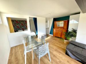 a living room with a glass table and a couch at Logement entier indépendant dans une maison calme avec jardin barbecue face aux vignes pouvant accueillir cette personne très bien si tu es à 5 minutes de Saint-Émilion 5 minutes du centre-ville de Libourne et 5 minutes de l'hôpital in Libourne