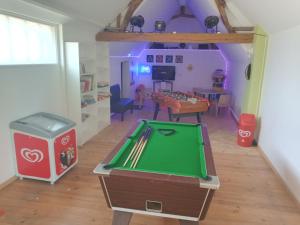 a room with a ping pong table and a living room at Camping de la Baie de Somme Nature Randonnées in Pendé