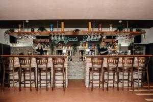 um bar com bancos de madeira num restaurante em Butenas Hotel Tyla em Biržai