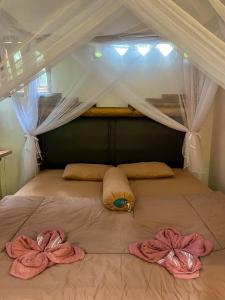 a bed with two towels on top of it at Garden Grove Guest House & Coffee Bar in Bukit Lawang
