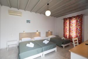 1 dormitorio con 2 camas y mesa en Marina Blue Ornos, en Ornos