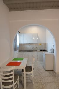 a kitchen with a table and chairs and an archway at Marina Blue Ornos in Ornos