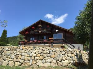 uma casa com uma parede de pedra em frente em Le chalet de Doucy Bardet em Habère-Poche