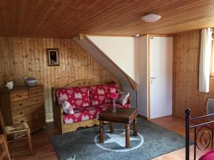 sala de estar con sofá rojo y mesa en Le chalet de Doucy Bardet, en Habère-Poche
