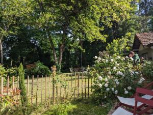 um homem num jardim com uma cerca e flores em L'annexe de la verrerie em Cognac