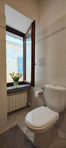 a bathroom with a white toilet and a window at La Corte Domodossola in Domodossola