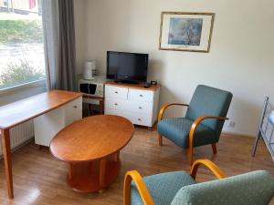 Habitación con mesa, sillas y TV. en Posio Apartments, en Posio